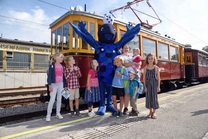 Kinder mit dem Maskottchen Perla vor dem Nostalgiezug des Kinderspaßes auf der Atterseebahn