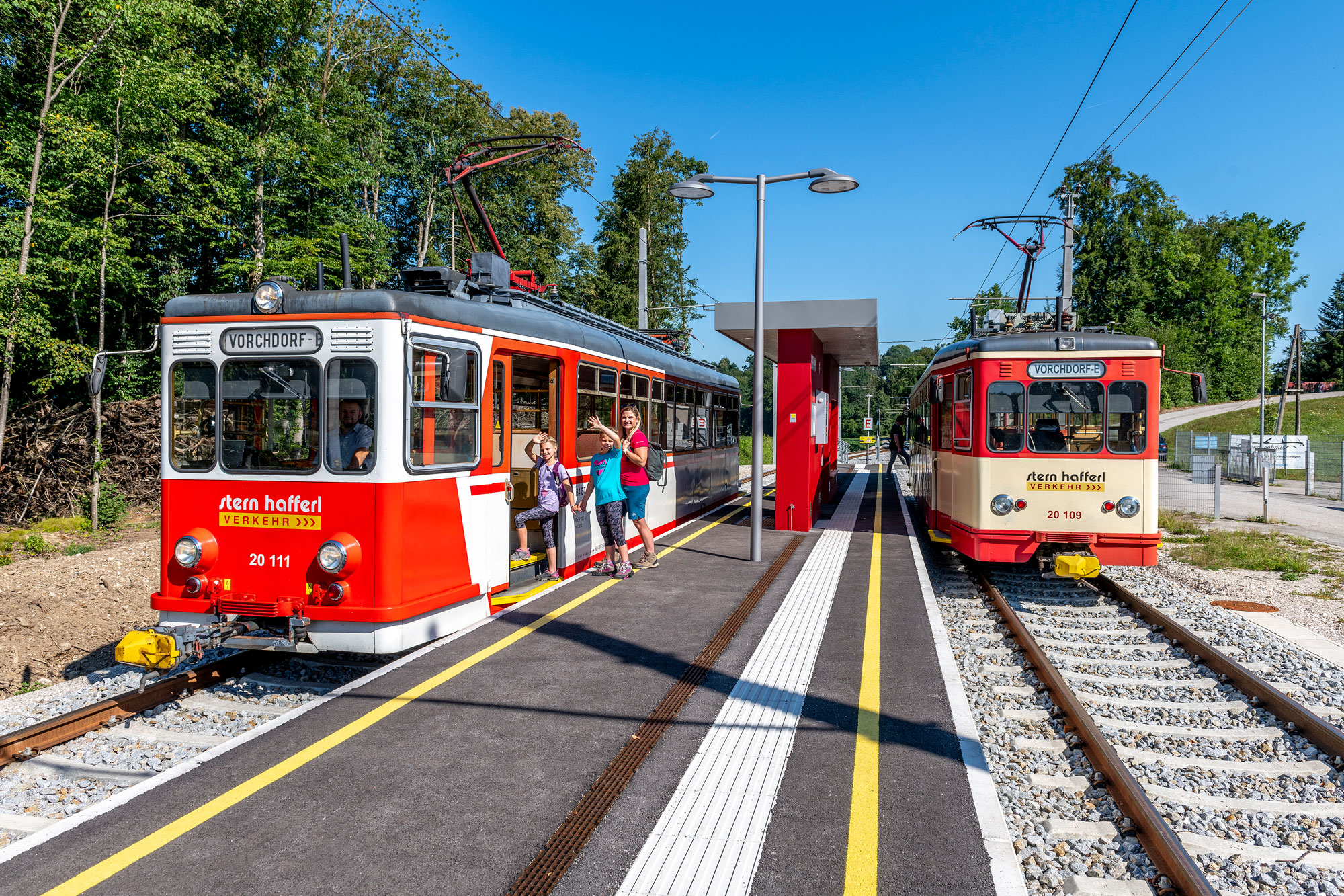 2 Fahrzeuge der Vorchdorferbahn nebeneinander auf einer Haltestelle