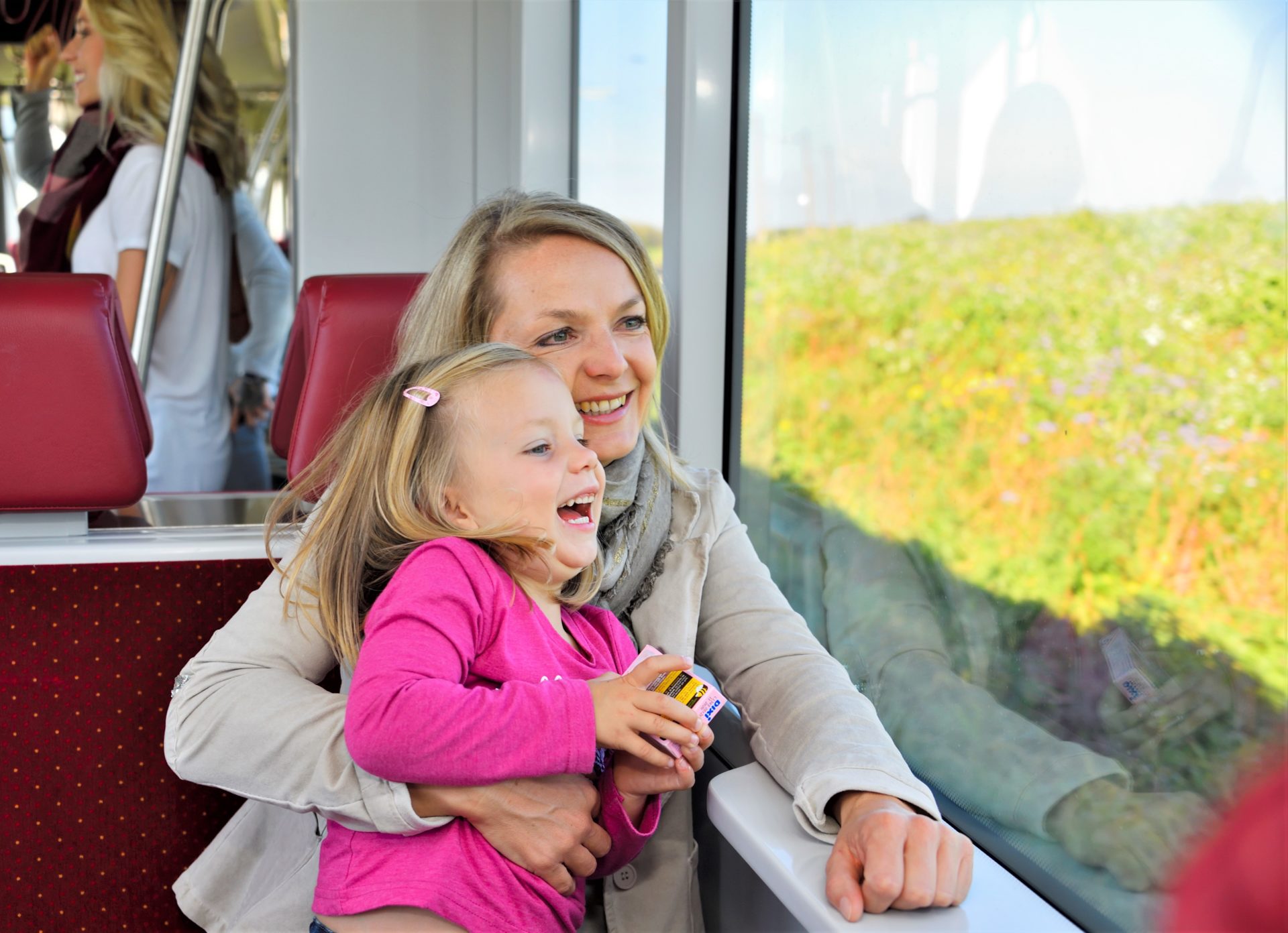 Mutter mit Kind im Zug, sehen lachend aus dem Fenster