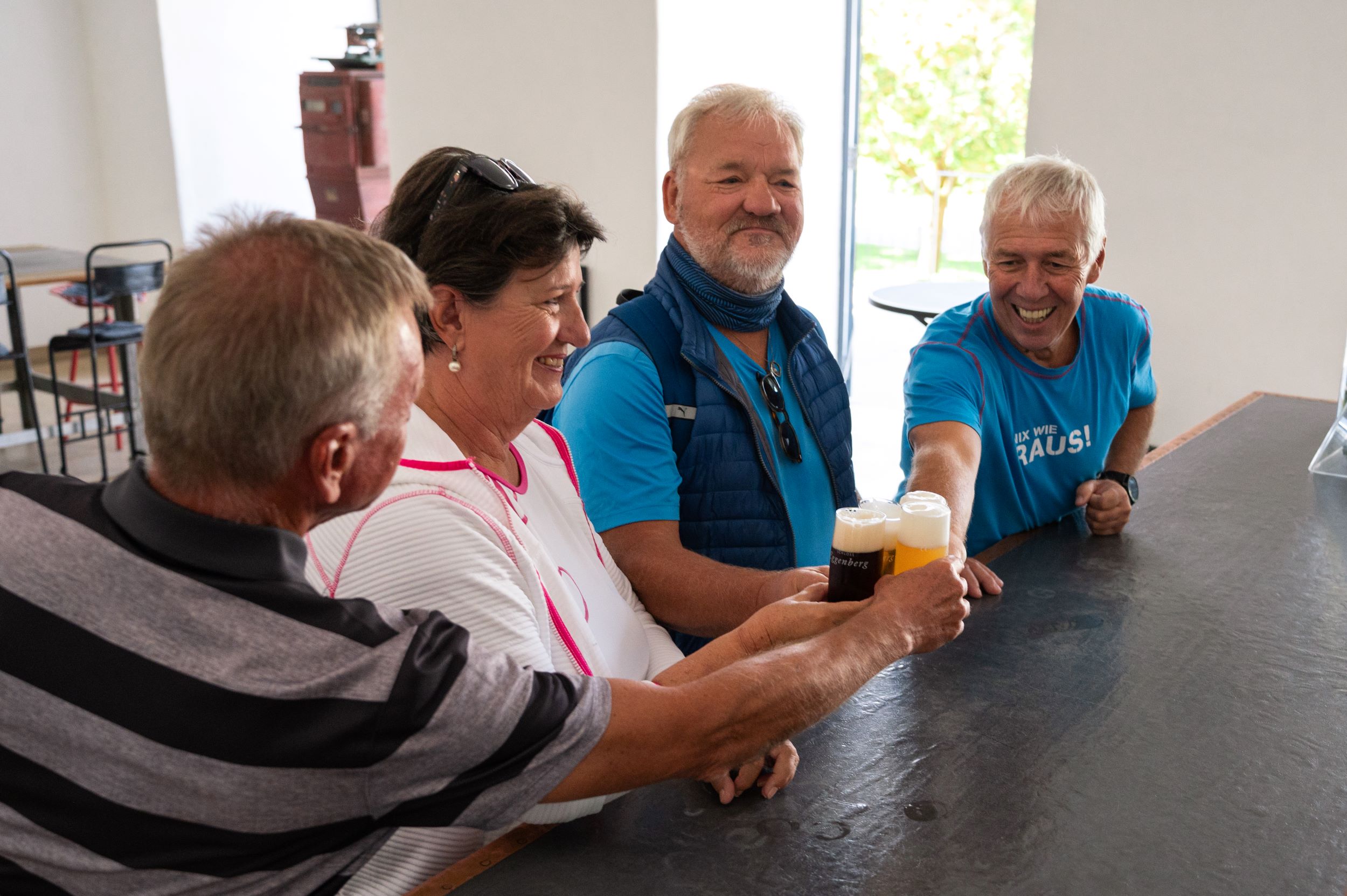 Personen stoßen mit Bier an