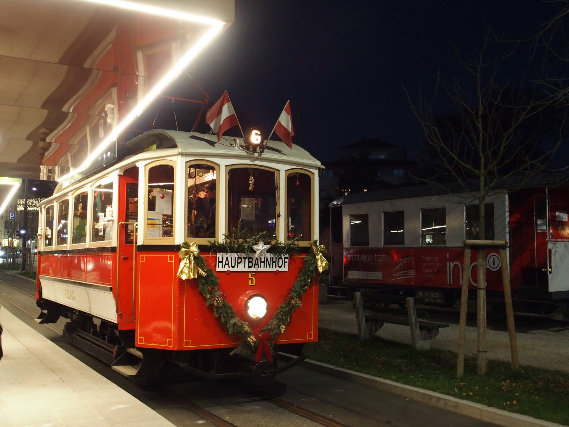 Nostalgiewagen GM5, geschmückt mit Blumen, in der Nacht, auf einer Haltestelle