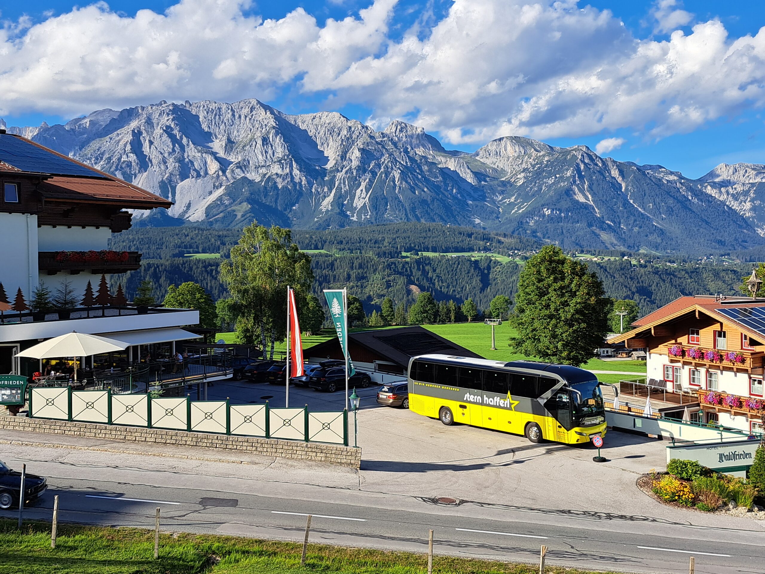Stern & Hafferl Bus auf einem Hotelparkplatz mit Bergpanorama im Hintergrund