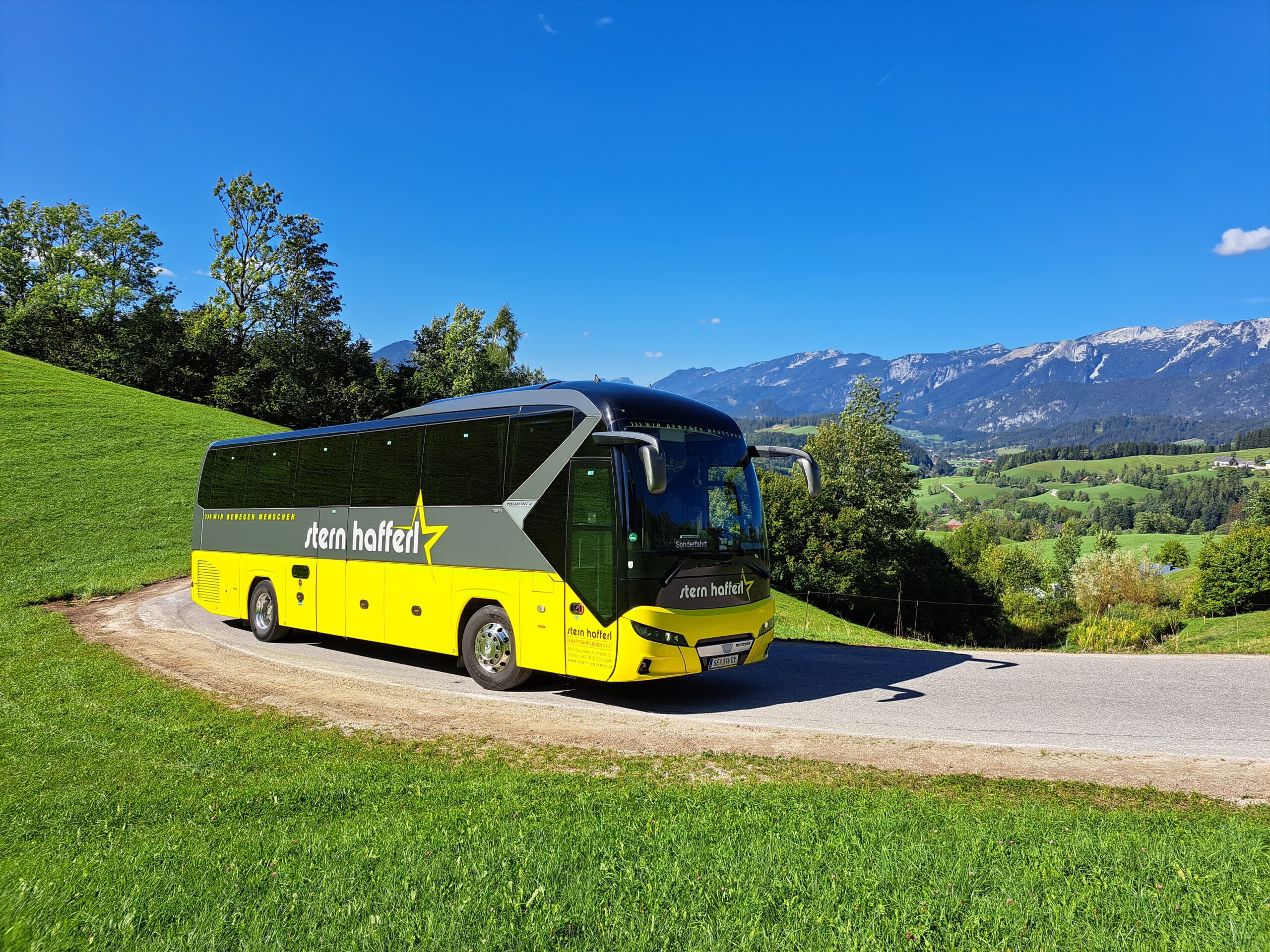 Stern & Hafferl Bus im Grünen vor einer schönen Berglandschaft