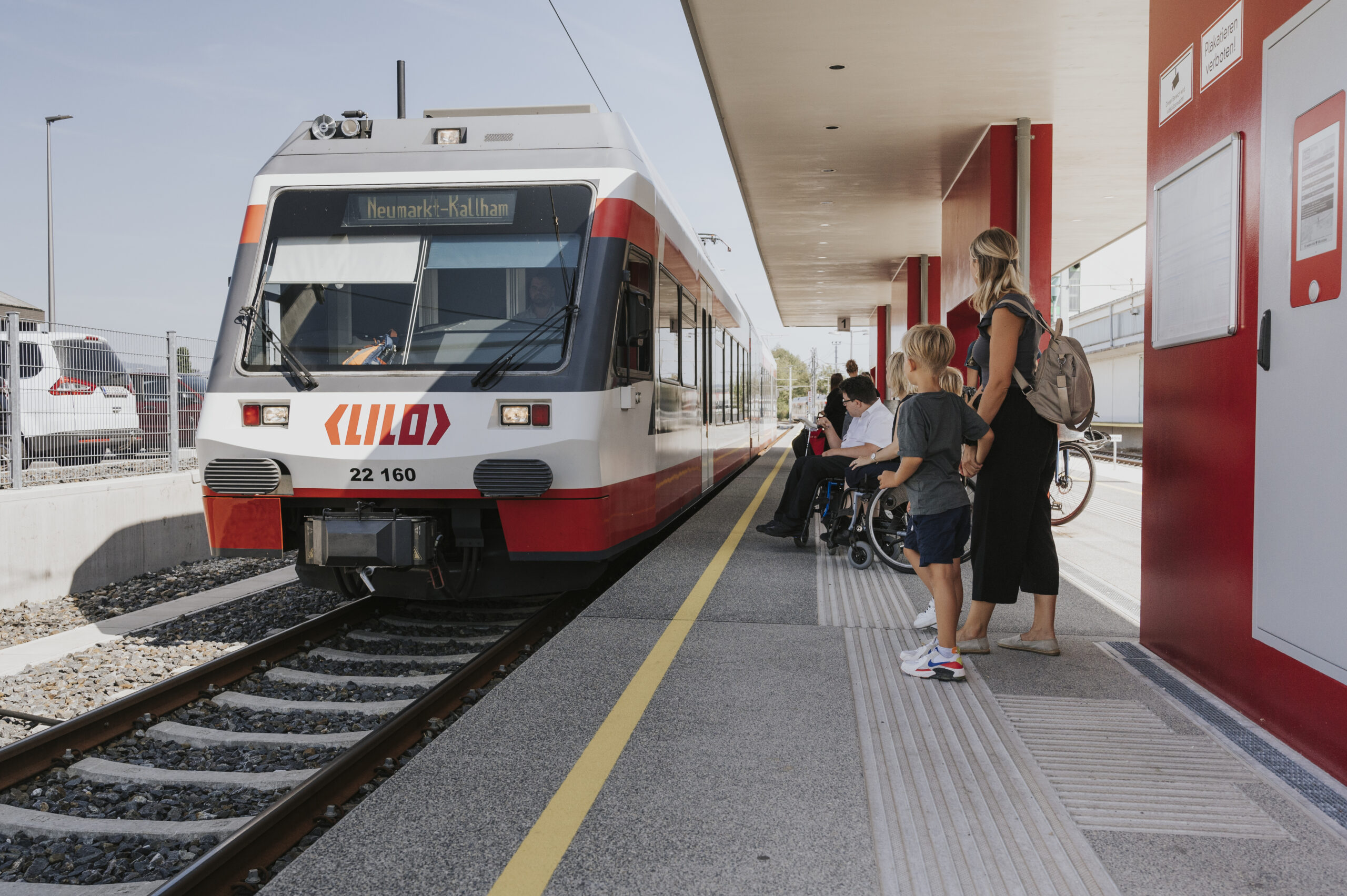 Mutter und Kind warten am Bahnsteig